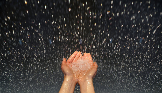 Enjoying rainfall. The rain falls and drops fall on his hand. Concept of nature and happy life. Rain