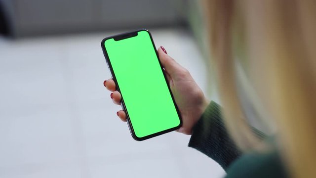 Close up hands woman holding use smartphone with vertical green screen mobile phone with chroma key technology information communication device business girl cellphone display slow motion