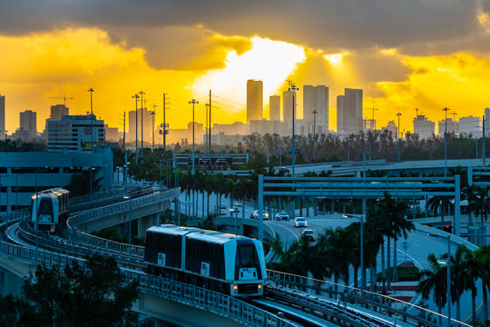 City skyline at sunrise with the MIA Mover, an automated people mover system at Miami International Airport designed to quickly transport land side passengers.