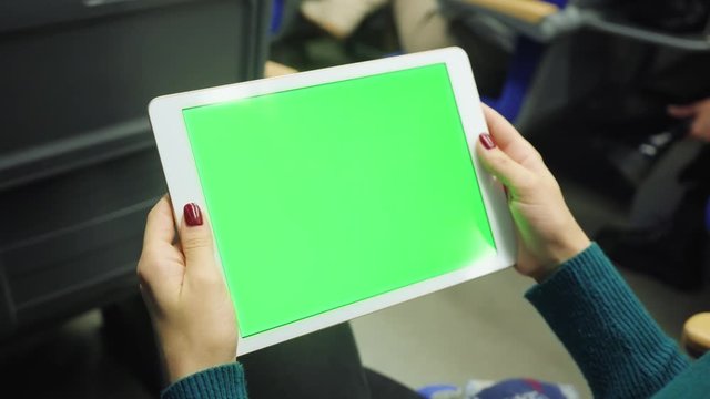 Close up hands woman hold horizontal tablet computer with green screen sitting in bus touch public communication adult finger chroma urban application digital scrolling slow motion