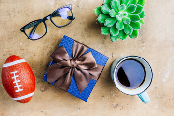 Flat lay Man set: cup of coffee, black notebook, ball and glasses on rustic beige background. Top view.