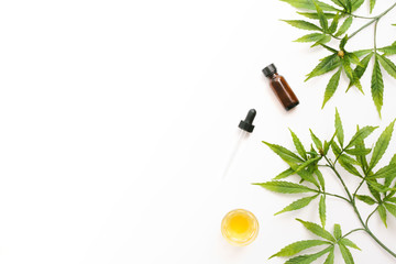 Glass bottles with CBD oil, THC tincture and hemp leaves on a white background. Flat lay, minimalism. Cosmetics CBD oil.
