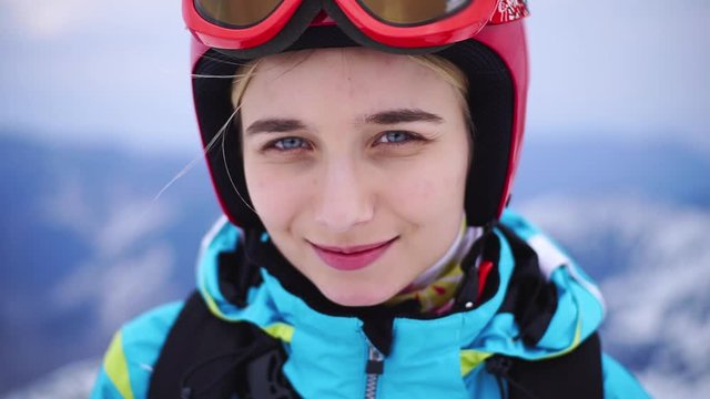 Portrait face smiling young caucasian woman feel happy skier climbs the ski lift up the mountain winter and resting in the mountains resort close up slow motion