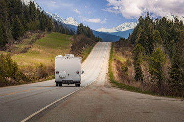 Tourists driving down the roads of the Canadian Rockies in an RV on a beautiful summer day