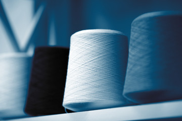 Classic blue threads, skeins and tangles of Italian wool yarn, knitting needles. Atelier sewing...