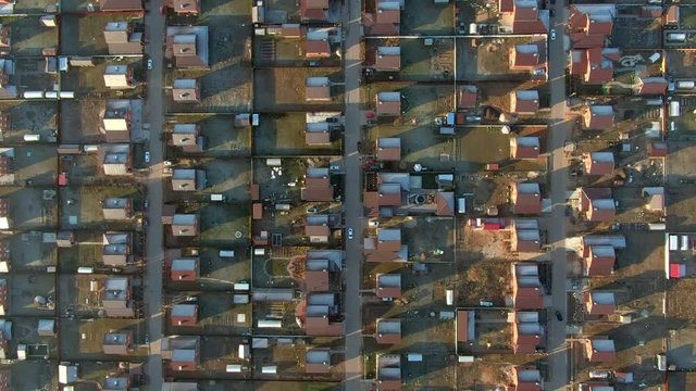 Top view from flying drone cottage village with same houses from red brick in countryside. Aerial view residential area with brick houses and villas in suburban