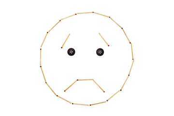 Smiley expressing emotion sorrow is made of matches on a white background