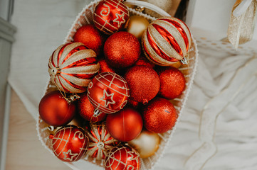 huge wicker basket filled to the top with red and golden balls to decorate a Christmas tree or apartment