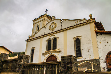 Historic Catholic church in Poços de Caldas, Brazil, featuring traditional architecture under a cloudy sky, creating a dramatic and timeless scene.