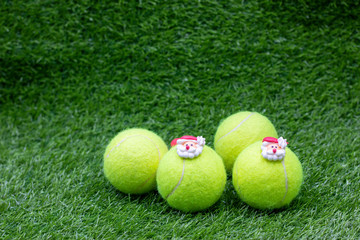 Tennis Christmas Holiday with Tennis balls and Santa Claus on green grass
