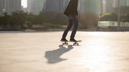 Obraz na płótnie Canvas Skateboarder skateboarding at sunset city