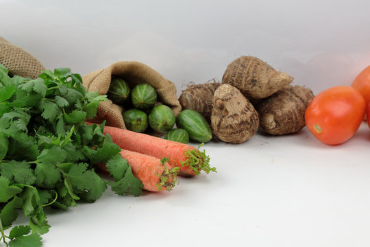 Indian vegetables of Tomatoes, carrots, Yams, Pointed gourd, Green chilies, ..Methi leaves, cilantro, and egg plants with copy space.