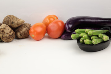 Indian vegetables of Tomatoes, carrots, Yams, Pointed gourd, Green chilies, ..Methi leaves, cilantro, and egg plants with copy space.