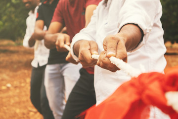 Close up of hands playing tug of war - Group of friends playing outdoor games in changing digital and technology world. - obrazy, fototapety, plakaty