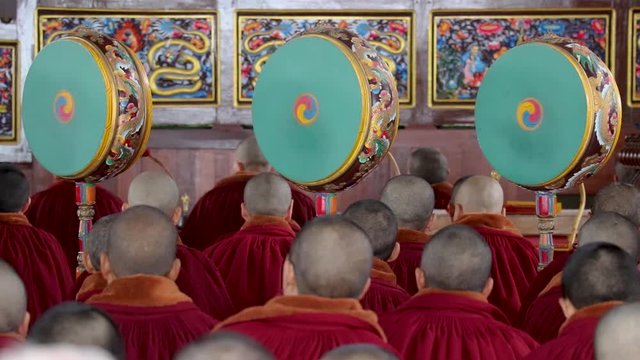 monks playing the ritual drums inside a monastery in ladakh during a religious ceremony