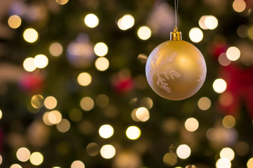 hand made ornament hangs in front of christmas background