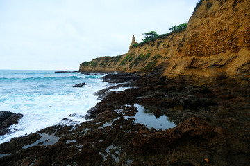 Waves on the seaside are splashing on the rocks in a stormy day