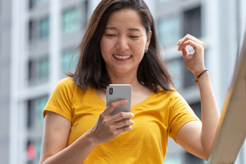 woman using cell phone.hand holding texting message on mobile chatting friend ,search internet information at outdoor office.technology device contact communication connecting people concept