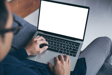 mockup image blank screen computer with blank white background for advertising text,hand man using laptop contact business search information on desk at home office.marketing and creative design