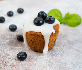 Delicious vanilla muffin in sugar Fudge lie on a concrete background. Horizontal photo.