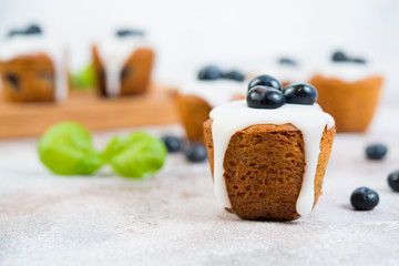 Delicious vanilla muffins in sugar Fudge lie on a concrete background. Horizontal photo.