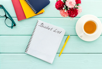 Bucket list. Blank notebook to write goals and wishes on green wooden office desk top-down mockup