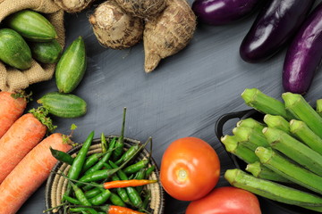 Indian vegetables of Tomatoes, carrots, Yams, Pointed gourd, Green chilies, Methi leaves, cilantro, and egg plants with copy space.