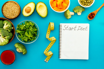 Diet program mockup. Start diet text in notebook near vegetables on blue background top view