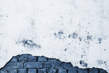Broken battered wall with stucco and bricks in classic blue. Beautiful tinted color 2020. Grunge background