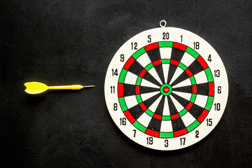 Goal achievement concept. Dartboard and arrows or dart on black background top view copy space