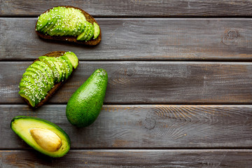 Healthy breakfast. Avocado toast on dark wooden background top view frame copy space