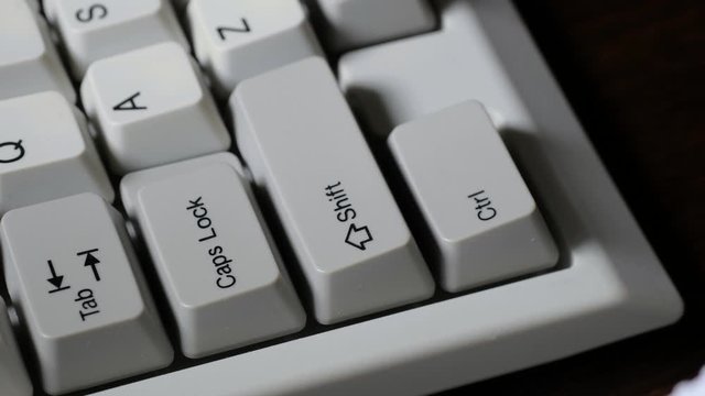 Finger presses left SHIFT button on keyboard