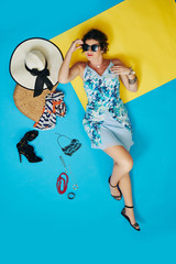 Happy woman lying on the floor with many necklaces and accessories around, view from the top