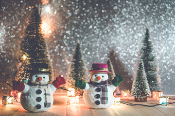 Snowman stand in pile of snow at silent night with Christmas tree and ornament, light up glitter...