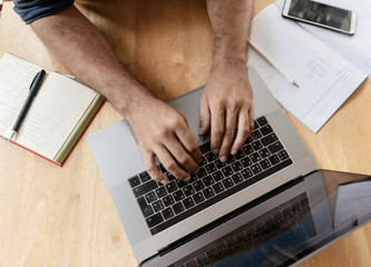 Male hands on laptop keyboard, shot from above. Technology Creativity Remote Work Freelancer Concept © olezzo