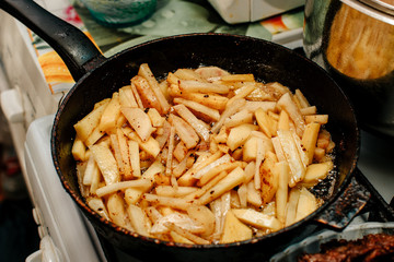 Potatoes fried in a pan in the kitchen