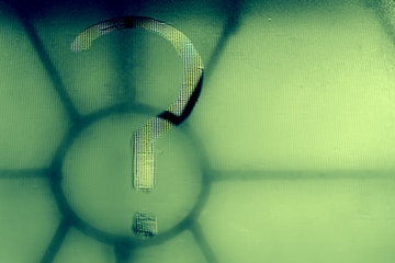 Question mark written on the misted glass of a window closed by a bars