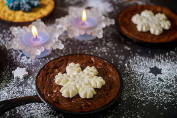 Fototapeta na wymiar Homemade chocolate chip cookie and brownie decorated with snowflake candy on iron skillet.