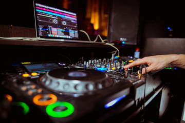 Dj mixing outdoor at beach party festival with crowd of people in background - Summer nightlife...