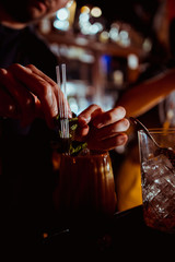 barman adding ingredients and creating cocktail drinks on bar counter