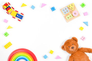 Baby kids toys background. Wooden educational geometric stacking blocks toy, wooden train, rainbow, teddy bear and colorful blocks on white background