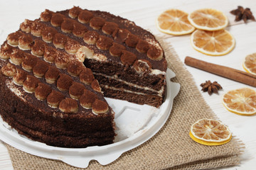 DeliciousTiramisu cake close-up on a white wooden background.