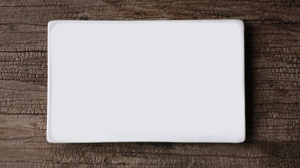  Top view of empty white food plate on a wood background                              