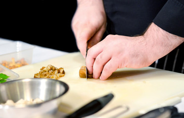 Obraz na płótnie Canvas Chef cuts the vegetables cooking in a kitchen, hands slicing vegetables, preparing vegetables