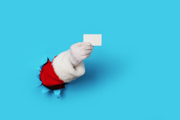 Santa Claus Holding a Blank White Card isolated over light blue