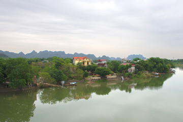 Fototapeta na wymiar Panoramic view of karst formations in Tam Coc, a part of Trang An Complex , was declared a UNESCO World Heritage Natural and Cultural Monument.Ninh Binh province, Vietnam