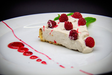 Raspberry cheesecake on black background