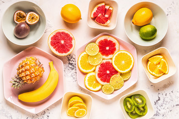 Tropical fruits whole and slices on plates