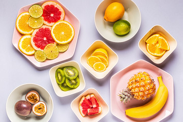 Tropical fruits whole and slices on plates