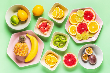 Tropical fruits whole and slices on plates